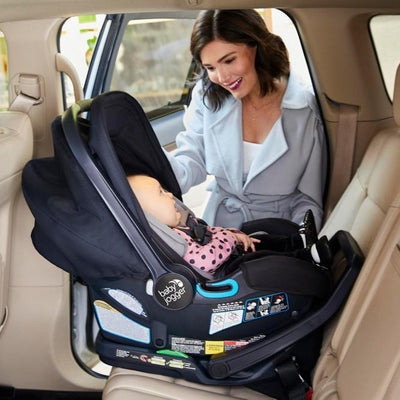 Mom placing Baby Jogger City Go 2 infant car seat in the car