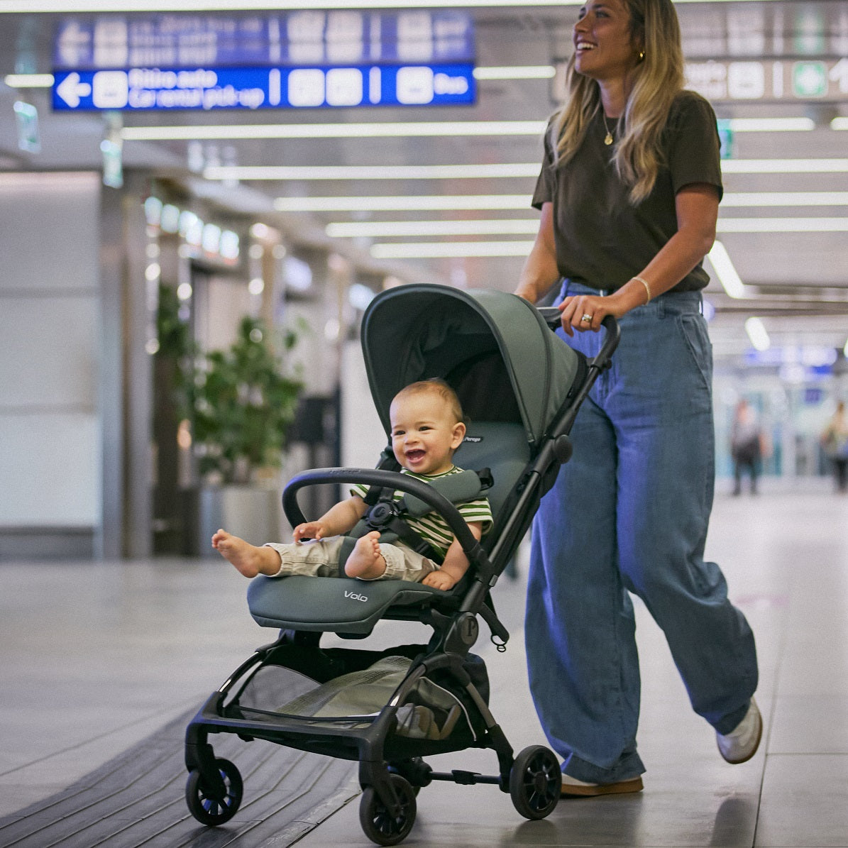 Woman pushing the Peg Perego Volo stroller with a baby inside in an airport