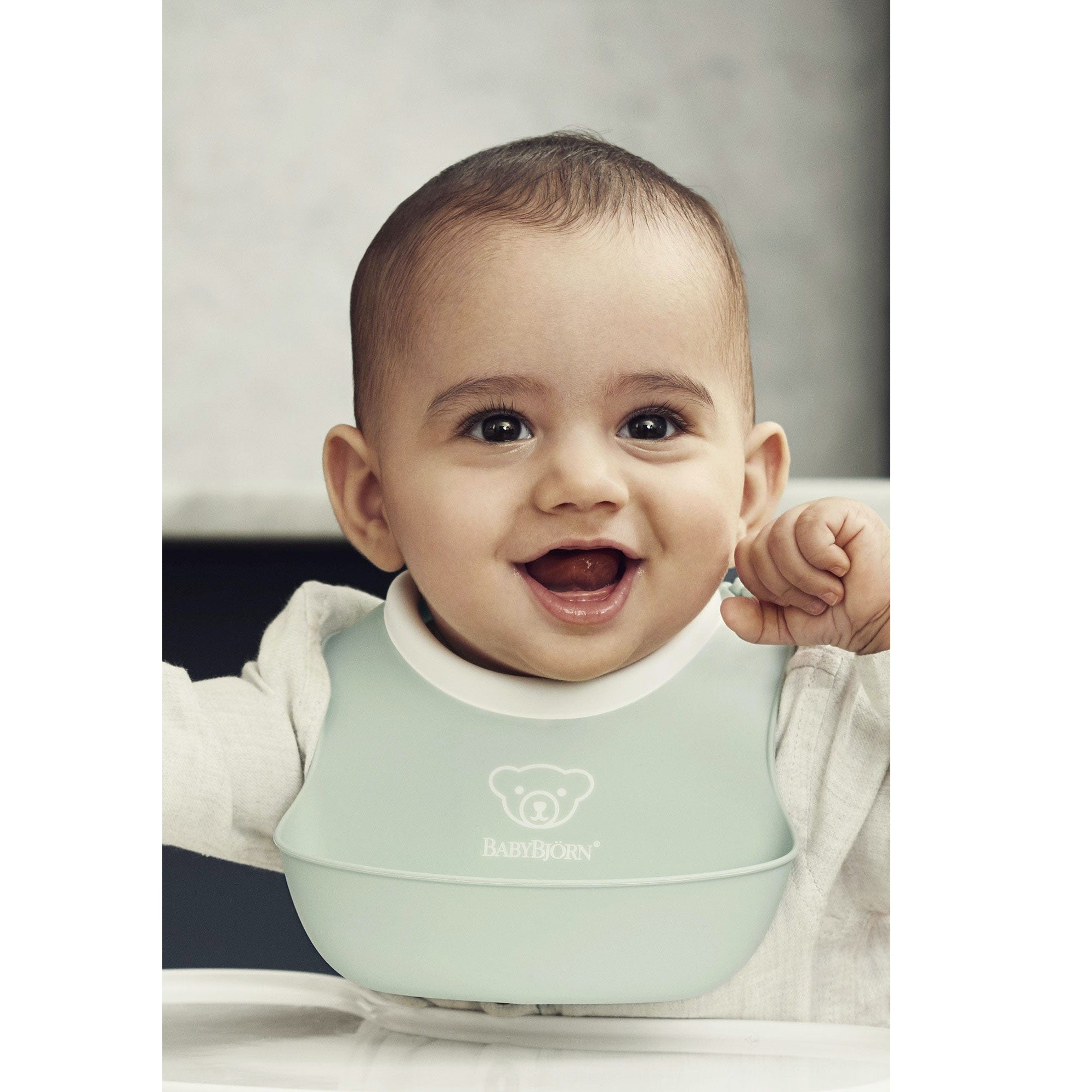 Baby wearing the BABYBJÖRN Small Baby Bib 2-Pack