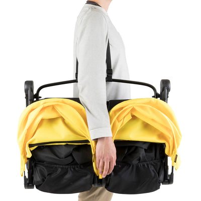 mom carrying Mountain Buggy Nano Duo Stroller in Cyber folded